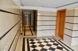 フンシャルにあるPalms Palace Funchal Suiteの白黒チェッカーの床の廊下