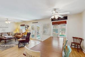 a living room with a ceiling fan and a dining room at Summer House in Edisto Beach