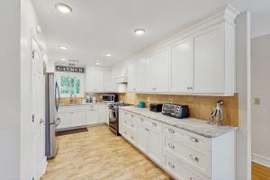 a large white kitchen with white cabinets and appliances at Summer House in Edisto Beach