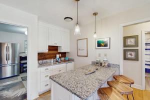 a kitchen with white cabinets and a granite counter top at Summer House in Edisto Beach
