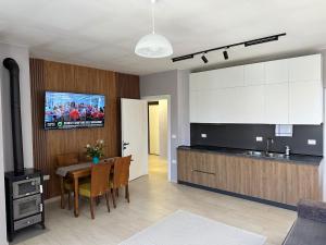 a kitchen and dining room with a table and a tv at River apartment in Tushemisht