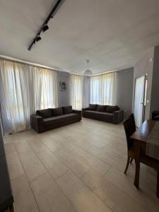 a living room with two couches and a table at River apartment in Tushemisht