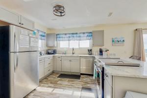 a kitchen with white cabinets and a refrigerator at Corrigan in Edisto Beach +13 photos