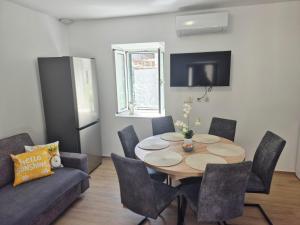 a dining room with a table and a couch at House Mateljan in Poljica