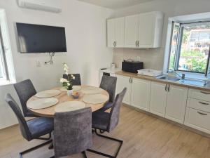a kitchen and dining room with a table and chairs at House Mateljan in Poljica