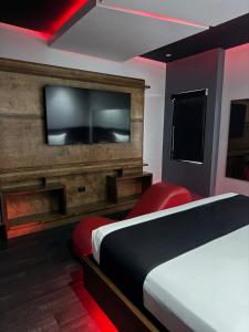 a hotel room with a bed and a flat screen tv at Motel Boutique Xpress in Ensenada +15 photos