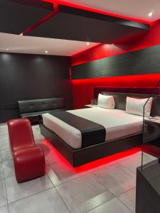 a bedroom with a bed and a chair in a room at Motel Boutique Xpress in Ensenada