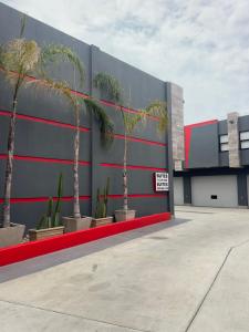 a building with palm trees in front of it at Motel Boutique Xpress in Ensenada