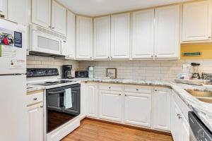 a kitchen with white cabinets and white appliances at The Retreat 7A in Edisto Beach