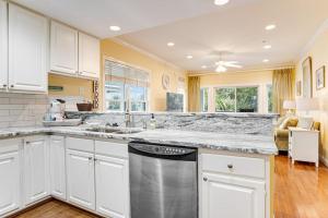 a kitchen with white cabinets and a dishwasher at The Retreat 7A in Edisto Beach +21 photos
