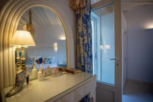 a bathroom with a counter with a lamp and a mirror at Fino Amore Private Jacuzzi Suite in Mykonos Town in Mikonos +65 photos