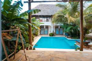 a swimming pool in front of a villa at Jaje Paje Villa in Paje
