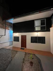 a house with a black wall and a wooden door at Munay House in Tarapoto