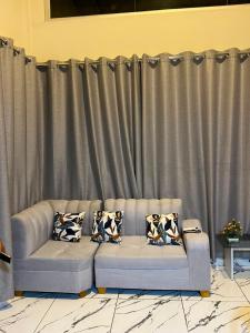 a couch with pillows in front of a curtain at Munay House in Tarapoto