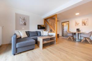 a living room with a couch and a table at Appartementhaus EifelAdventures in Berlingen