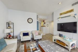 a living room with a large tv and a couch and chairs at Anchorage 7444 in Hilton Head Island