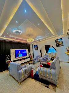 a living room with couches and a flat screen tv at Dreamland prestige Homes in Sasabi +6 photos