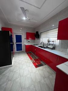 a kitchen with red cabinets and a white tile floor at Dreamland prestige Homes in Sasabi