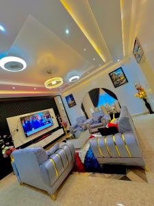 a living room with couches and a flat screen tv at Dreamland prestige Homes in Sasabi