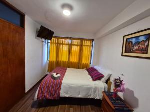 a bedroom with a bed and a television in it at VittoriaHouse in Ollantaytambo