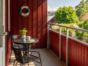 a patio with a table and chairs on a balcony at Klintehamn Rooms - Near the Sea in Klintehamn
