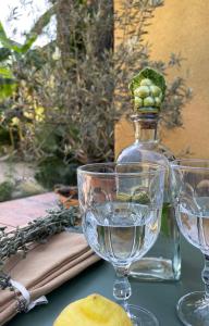 two wine glasses and a bottle of water on a table at Can TABERNER in Bigues i Riells