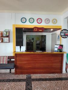 a store counter with clocks on the wall above it at HI Lagos - Pousada de Juventude in Lagos