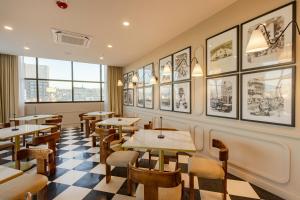 a restaurant with tables and chairs and pictures on the wall at Hotel Indigo Tijuana Downtown by IHG in Tijuana