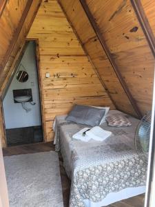 a room with two beds in a wooden cabin at Chalé Pingo de Ouro Socorro SP in Socorro