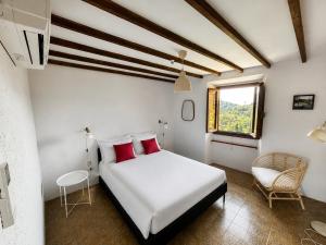 a bedroom with a white bed with red pillows and a window at Medici Villa with Gardens 7 min from Florence in Fiesole