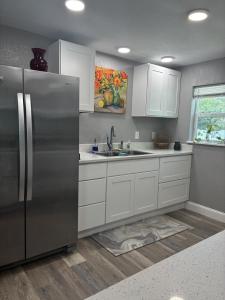 a kitchen with a stainless steel refrigerator and white cabinets at New Haven 5 mi from Legoland in Winter Haven