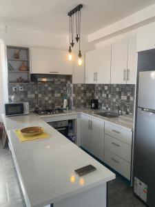 a kitchen with white cabinets and a counter top at T2 vue sur mer in Bejaïa +27 photos