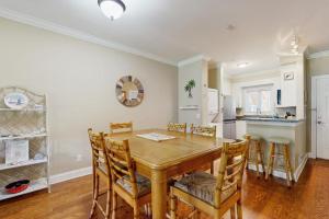 a kitchen and dining room with a wooden table and chairs at The Tidey Turtle in Edisto Beach