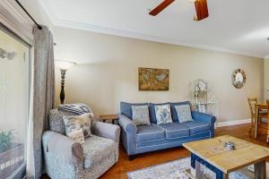 a living room with a blue couch and a table at The Tidey Turtle in Edisto Beach