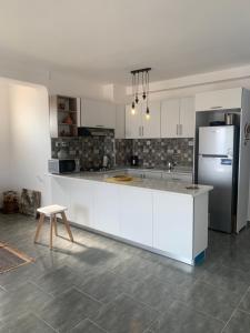 a kitchen with white cabinets and a refrigerator at T2 vue sur mer in Bejaïa