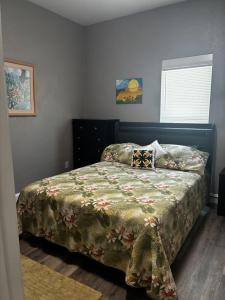 a bedroom with a bed with a green comforter at New Haven 5 mi from Legoland in Winter Haven