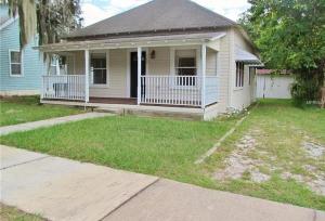 a small white house with a porch and a yard at New Haven 5 mi from Legoland in Winter Haven