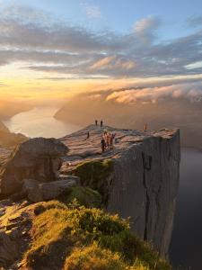 a group of people standing on top of a cliff at Leilighet Preikestolen in Strand
