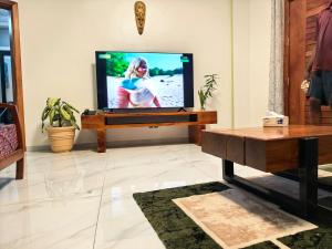 a living room with a television and a table at OLA LUXURY HOTEL Parakou in Parakou