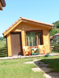 een hut met twee stoelen en een tafel ervoor bij Вилно селище МИРОВЕЦ in Malŭk Izvor