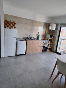 a kitchen with white appliances and a tile floor at Apartment 1 block from the sea in Mar de Ajó