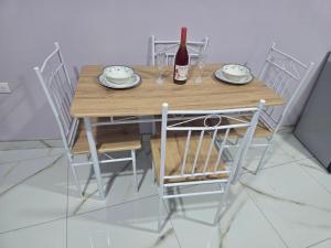a wooden table with chairs and a bottle of wine at Apartamentos Torres Manuel Antonio in Manuel Antonio