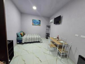 a room with a bed and a table and a television at Apartamentos Torres Manuel Antonio in Manuel Antonio