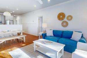 a living room with a blue couch and a table at Sea Sea Rider in Edisto Beach