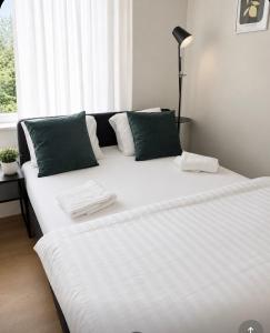 a large white bed in a room with a window at Nordhaven Sundbyberg in Sundbyberg