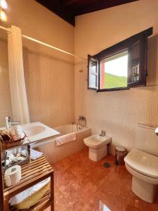 a bathroom with a tub and a toilet and a sink at Hotel Rural El Fundil in El Pino +50 photos