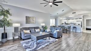 a living room with blue couches and a kitchen at Pet-Friendly Luxury 3BR with Pool Sleeps 8 Near Beach in Myrtle Beach