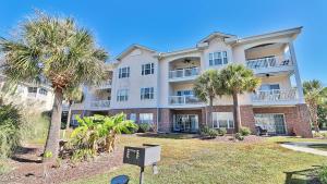 a large building with palm trees in front of it at Pet-Friendly Luxury 3BR with Pool Sleeps 8 Near Beach in Myrtle Beach