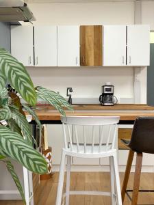 a kitchen with white cabinets and a white chair at El Martín Pescador in Osorno