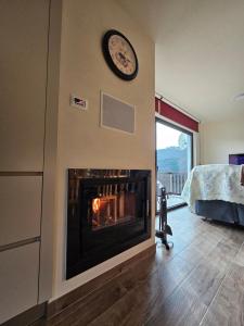 a fireplace in a room with a clock on a wall at Casa dos Pobres in Castro Daire